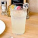 An Arcoroc English Pub glass filled with liquid on a table.