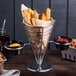 An American Metalcraft stainless steel serving basket with fries and dipping sauces on a table.