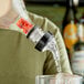 A person using a Choice 3-ball measured liquor pourer to pour liquid into a glass on a counter.