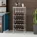 A Regency wire wine rack with wine glasses and bottles on a shelf.