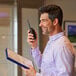 A person holding a Midland BizTalk Industrial Grade Two-Way Business Radio and a clipboard.