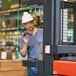 A man wearing a white hard hat holding a Midland BizTalk two-way business radio.