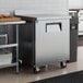 A stainless steel worktop freezer with a backsplash and a single door on casters.