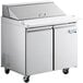 An Avantco stainless steel refrigerated sandwich prep table with wheels.