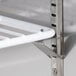 A close-up of a metal shelf with a white bar.