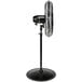 A Tornado black metal pedestal fan on a stand.