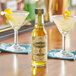 A bottle of Scrappy's Lime Bitters on a table with a glass of liquid.