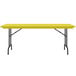 A yellow rectangular Correll folding table with black legs.