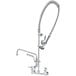 A T&S wall-mounted pre-rinse faucet with a hose and sprayer.