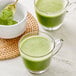 A spoon with Jade Leaf Organic Ceremonial Matcha Powder in a bowl of green powder.