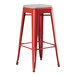 A Lancaster Table & Seating red metal outdoor barstool with a gray seat cushion.