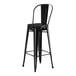 A Lancaster Table & Seating black outdoor cafe barstool with black cushion.