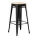 A Lancaster Table & Seating black outdoor bar stool with a tan cushion.