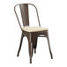 A brown metal Lancaster Table & Seating outdoor cafe chair with a tan cushion.