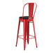 A Lancaster Table & Seating red metal outdoor restaurant bar stool with black cushion.