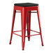 A Lancaster Table & Seating Alloy Series Ruby Red outdoor backless counter height stool with black cushion.