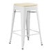 A white Lancaster Table & Seating outdoor backless counter height stool with a tan cushion on the seat.