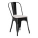 A black metal Lancaster Table & Seating outdoor cafe chair with a gray cushion.