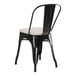 A black metal Lancaster Table & Seating outdoor cafe chair with a gray cushion.