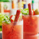 Two glasses with a Benny's Original Smokin' Chipotle Meat Straw in a drink garnished with vegetables.