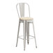 A Lancaster Table & Seating silver metal bar stool with a tan cushion.