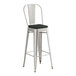 A Lancaster Table & Seating metal barstool with black cushion.
