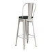 A Lancaster Table & Seating metal barstool with black cushion.
