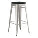 A Lancaster Table & Seating metal barstool with a black cushion.