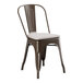 A brown Lancaster Table & Seating outdoor cafe chair with a white cushion.