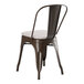 A brown Lancaster Table & Seating outdoor cafe chair with a white cushion.