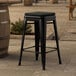 A Lancaster Table & Seating black outdoor backless counter height stool with a black cushion.