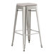 A Lancaster Table & Seating silver metal backless barstool with a gray cushion.