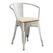 A Lancaster Table & Seating metal arm chair with a tan cushion.