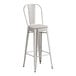 A Lancaster Table & Seating metal bar stool with a gray cushion.