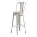 A Lancaster Table & Seating metal barstool with a gray cushion.