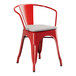 A Lancaster Table & Seating red metal outdoor arm chair with a gray cushion.