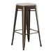 A brown metal backless barstool with a gray cushion.