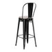 A black bar stool with a gray cushion.