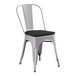 A Lancaster Table & Seating grey metal outdoor cafe chair with black cushion.