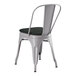 A Lancaster Table & Seating gray metal outdoor cafe chair with a black cushion.