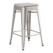 A silver metal Lancaster Table & Seating backless counter height stool with a gray cushion.