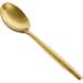 The front of a matte brass Owen dinner/dessert spoon with a wooden handle.