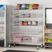 A Regency chrome mobile storage display stand with baskets holding boxes of food.