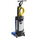 A white and blue Clarke walk behind cylindrical floor scrubber with a yellow tube.