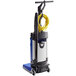 A Clarke MA10 12E walk behind cylindrical floor scrubber in blue and black with a yellow tube.