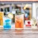 Arcoroc Essentials Cooler Glasses filled with a variety of different colored drinks on a table.