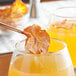 A pair of glasses with a dried fuyu persimmon slice in a glass of orange juice.