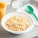 A bowl of Kellogg's Rice Krispies cereal with milk being poured into it.