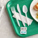 a plastic spoon fork and knife on a green tray