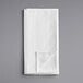A folded white napkin on a gray surface.